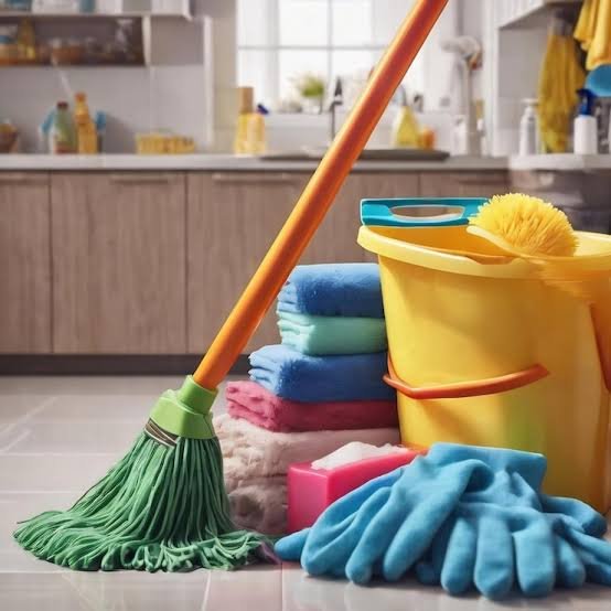 Housekeeper handling general housekeeping by wiping bathroom surfaces and checking floor cleanliness